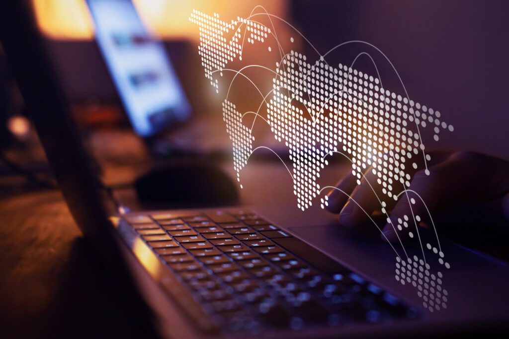 Laptop with digital world map overlay representing Amazon Web Services and global cloud infrastructure